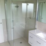 glass shower with white cabinets